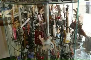 Signed guitars and collectables displayed in a glass cabinet at Art Effects Southampton